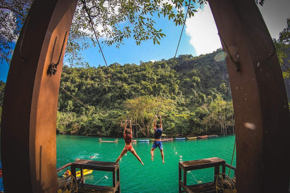 Adventurer ziplining over a river at Phong Nha National Park
